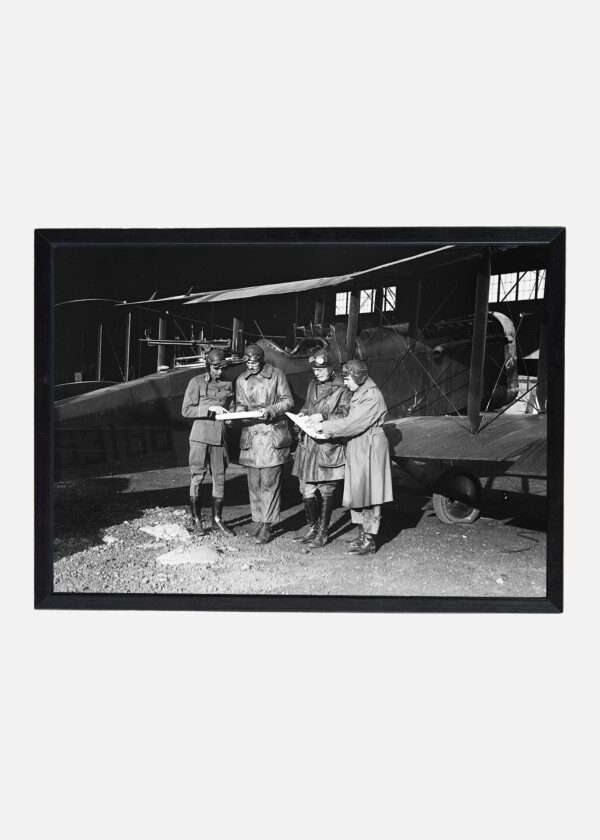 GROUP OF PILOTS NEXT TO VINTAGE AIRPLANE
