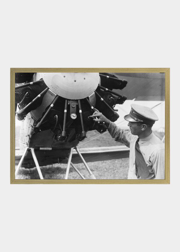 MAN INSPECTING AIRPLANE ENGINE