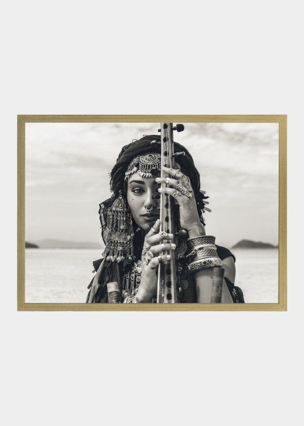 BEAUTIFUL YOUNG STYLISH TRIBAL WOMAN IN ORIENTAL COSTUME PLAYING SITAR OUTDOORS