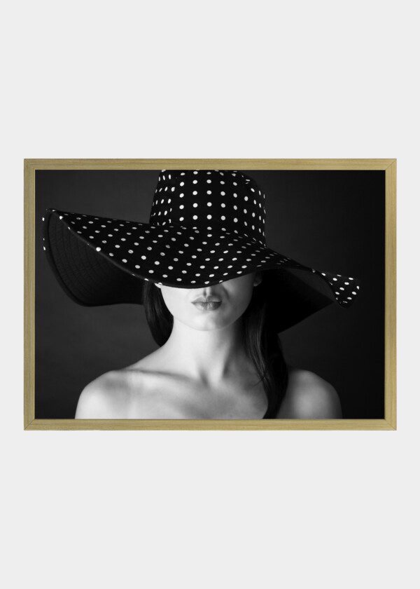FASHION PORTRAIT OF A WOMAN WITH BLACK AND WHITE DOTS HAT AND POUT LIPS