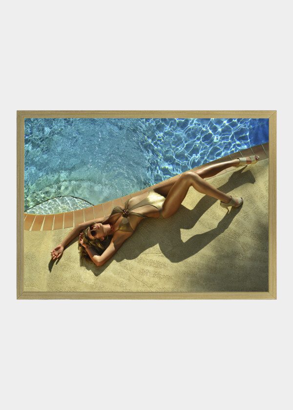 FASHION MODEL POSING PRETTY BY SWIMMING POOL