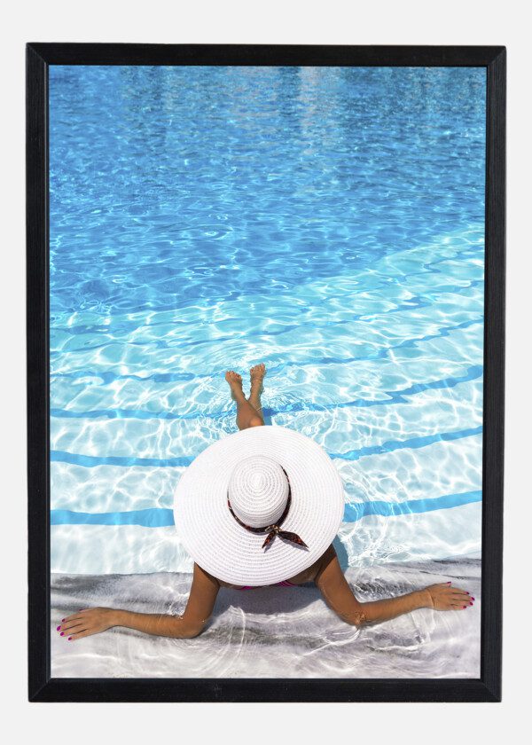 ELEGANT WOMAN WITH WHITE HAT ENJOYS THE POOL