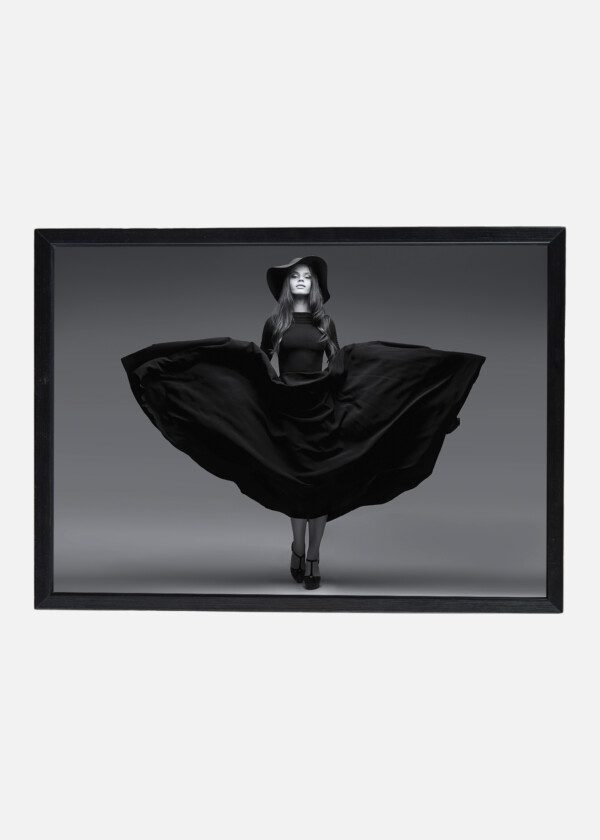 HIGH FASHION SHOT OF ELEGANT WOMAN IN A HAT AND LONG FLUTTERING DRESS
