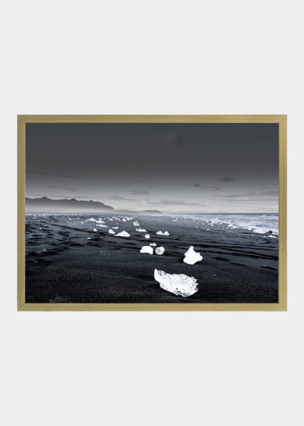 PHOTOGRAPH OF THE REYNISFJARA BEACH IN ICELAND WITH CHUNKS OF ICE