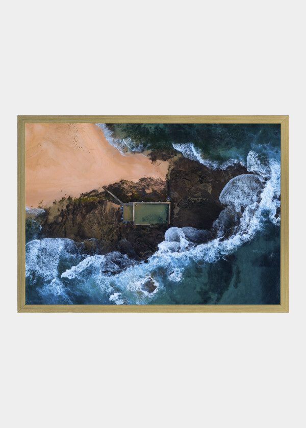 TOP DOWN AERIAL VIEW OF EMPTY ROCK POOL AT MONA VALE BEACH SYDNEY WITH WAVES CRASHING